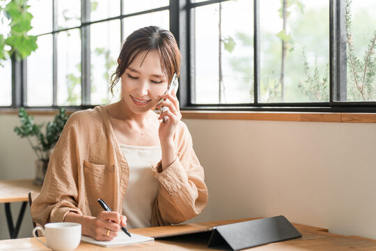 A young Asian woman working remotely/as a digital nomad at a cafe.
