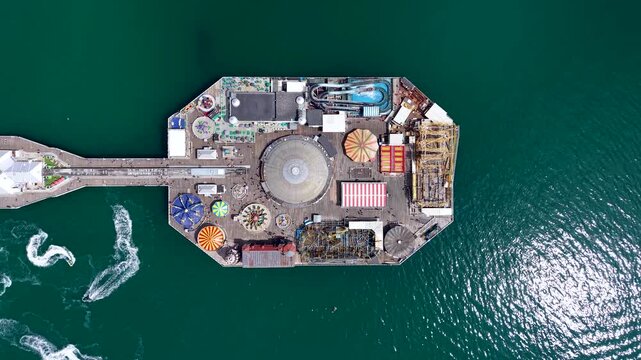 Aerial overhead view of the Brighton Pier in East Sussex, England, with fun fair and water sport action