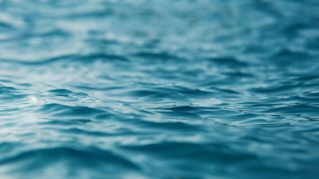 Close-up view of shimmering blue ocean waves creating mesmerizing patterns under natural light