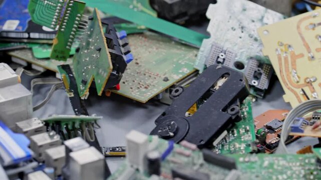 4K Video of pile of disassembled electronic waste with circuit boards, microchips, computer components, and plastic casings, showcasing e-waste recycling, technology disposal, hardware salvage