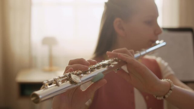 Medium close up shot of Caucasian girl practicing flute during music lesson at home. Ideal for promoting music education, arts programs, and private tutoring services