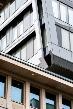 A sharp corner pulls the modern building facade into view where architecture, window bands, urban cladding, glass, and office angle meet