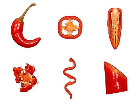 Dynamic composition of red chili pepper parts, including whole, sliced, and seeds, for food imagery.