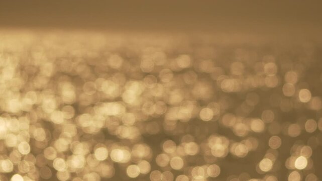 Ocean bokeh golden light and soft water reflection at sunset create a peaceful abstract background for relaxation and meditation