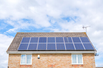 Fototapeta premium Residential property fitted with rooftop solar panels producing clean renewable electricity