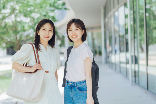 大学のキャンパスを歩く女子大生二人組