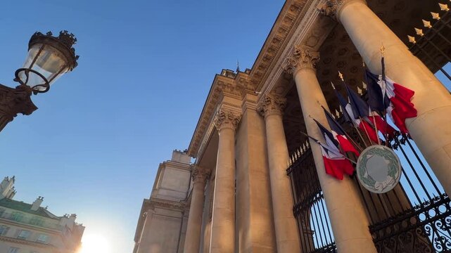 Palais Bourbon, housing the French National Assembly, featuring classical architecture with columns and a detailed facade, representing French law and politics under a clear blue sky