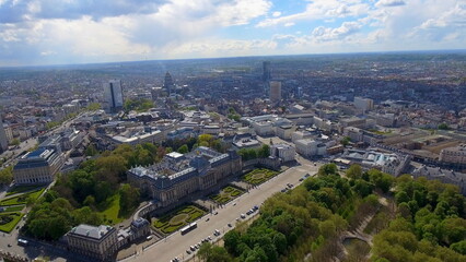 Fototapeta premium 4K aerial drone view of Brussels, Belgium. Panoramic cityscape featuring the historic Royal Palace of Brussels, Brussels Park, and distant skyline.