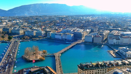 Obraz premium 4K aerial drone view of Geneva, Switzerland. Panoramic cityscape featuring Lake Geneva, Rhone River, Rousseau Island, and Pont du Mont-Blanc.