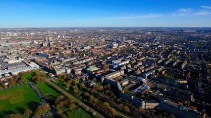 Obraz premium 4K aerial drone view of a South London residential neighborhood. Wide cityscape featuring urban housing estates, Burgess Park, and sports pitches.