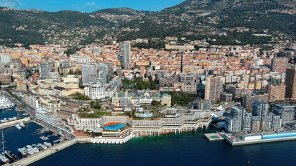 Naklejka premium 4K aerial drone view of Monte Carlo, Monaco. Luxury seaside cityscape featuring the iconic Monte Carlo Casino, Port Hercule, and Mediterranean.