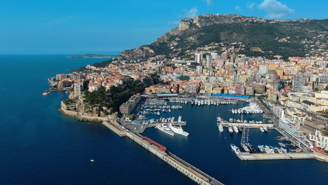 4K aerial drone view of Port Hercule in Monaco. Beautiful luxury marina cityscape featuring superyachts, Monaco-Ville, and the Mediterranean Sea.