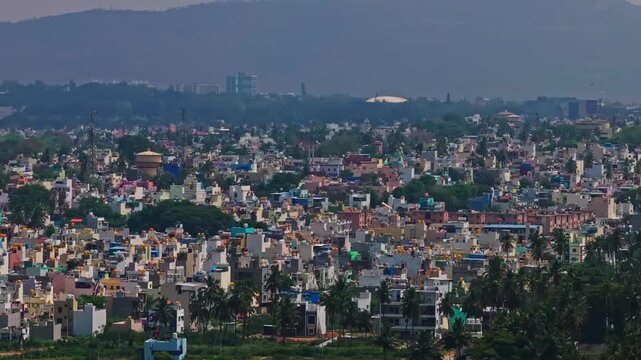 closeup shot of residential buildings with water tank, signal tower, trees, haze and mountain at R.S.Naidu Nagar, Hale Kesare, mysuru, karnataka, india. day time, semi circle shot, drone shot, 4k.