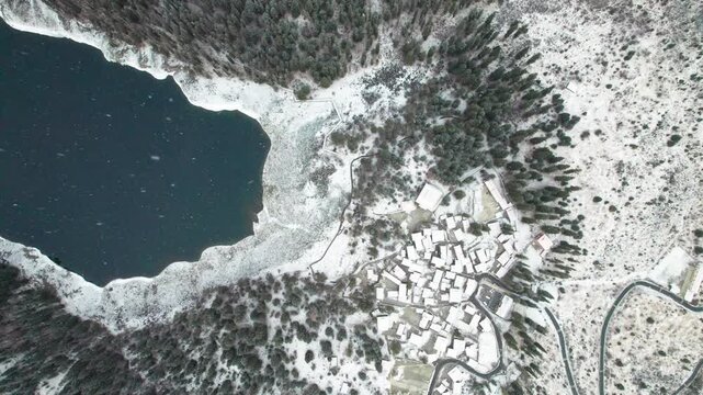 Drone view of lover sea, Changhaizi or qingrenhai, alpine glacial lake in Jinchuan, Aba, northwest Sichuan, China, white snow flakes falling to village and lake, 4k real time footage, travel concept.
