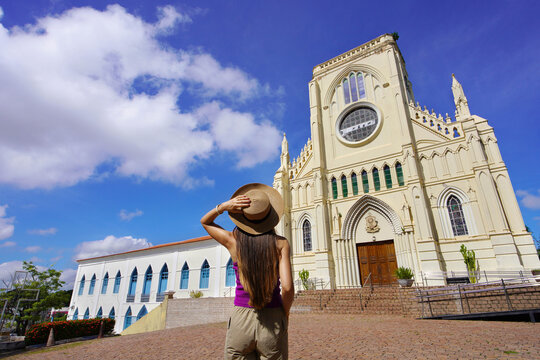 Tourism in Mato Grosso. Back view of young tourist woman visiting Nossa Senhora do Bom Despacho church in Cuiaba, Mato Grosso, Brazil.