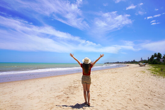 Young woman with open arms on Joao Pessoa beach, Brazil