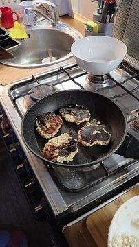 Homemade food preparation showing overcooked cottage cheese patties on stove