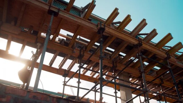 Below, wooden and beam with scaffolding for construction, building structure and rooftop support. Timber, installation and equipment for height safety, architecture design and project development