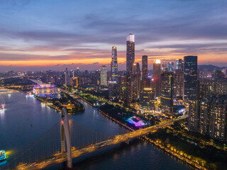 Fototapeta premium Aerial View of Guangzhou Skyline at Dusk with Illuminated Buildings and River