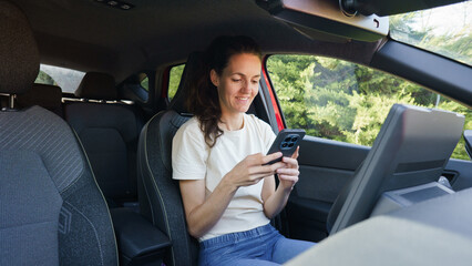 Naklejka premium Woman using smartphone inside a car
