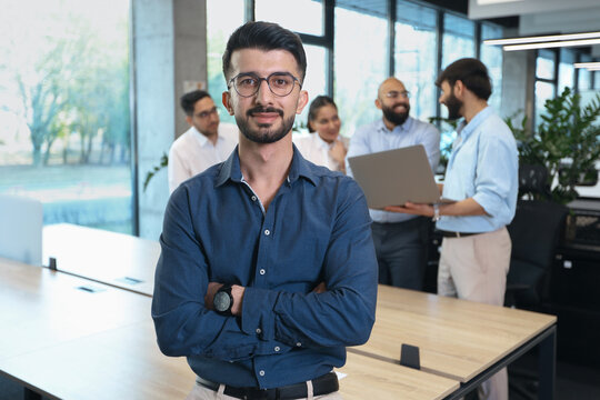 A man in a blue shirt stands in front of a group of people