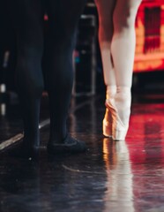 Ballet dancers couple during performance repetition, classic ballet rehearsal practicing in ballroom, view of legs in pointe shoes, ballerina and ballet dancer on a concert hall theatre stage floor © tsuguliev