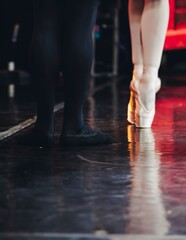 Ballet dancers couple during performance repetition, classic ballet rehearsal practicing in ballroom, view of legs in pointe shoes, ballerina and ballet dancer on a concert hall theatre stage floor © tsuguliev