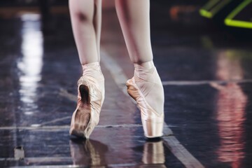 Ballet dancers couple during performance repetition, classic ballet rehearsal practicing in ballroom, view of legs in pointe shoes, ballerina and ballet dancer on a concert hall theatre stage floor © tsuguliev
