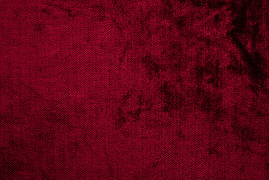 Dark red purple crushed velvet texture background, luxury burgundy velour fabric with soft shiny pattern.