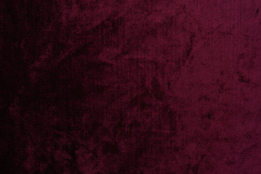 Dark red purple crushed velvet texture background, luxury burgundy velour fabric with soft shiny pattern.