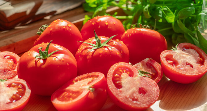 Fresh red tomatoes and slices with green leaves