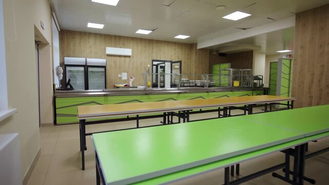 Color tables for children and stainless display in empty school canteen. Comfortable dining enclosure for students of education facility