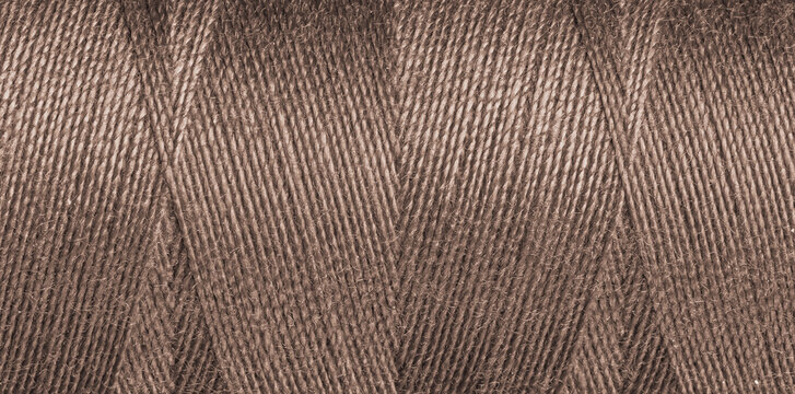 Close-up texture of Brown sewing threads on a spool