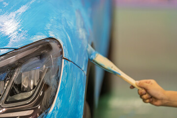 Workers apply blue car body wrap © Dong