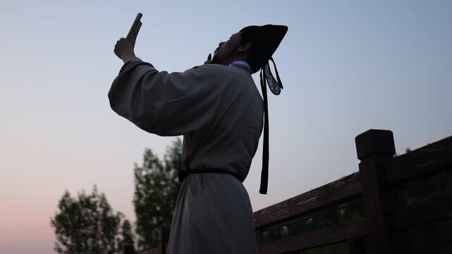 An ancient Chinese person reading alone at dusk