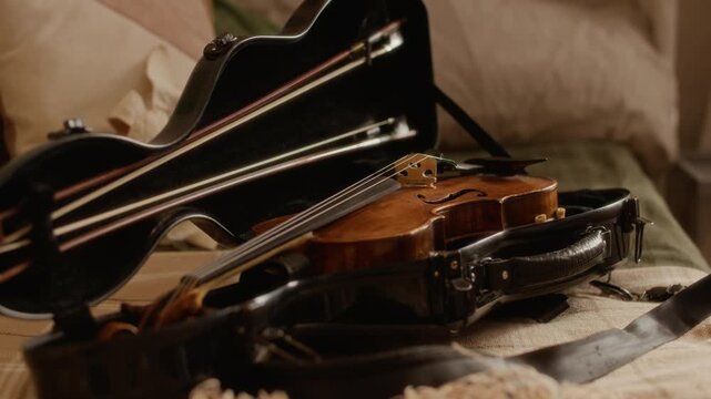 Zoom out shot of violin resting in open black case on bed, prepared for home music lesson. Clip is perfect for educational promos, music school advertisements, or classical instrument tutorials