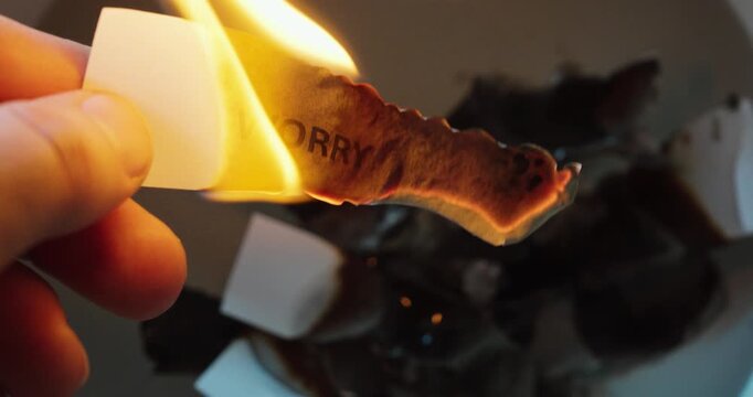 Close-up of a paper note with the word worry burning in a flame, symbolizing stress relief, anxiety, fear, letting go, and emotional release.