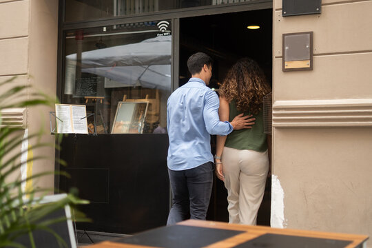 Couple entering restaurant for dinner date in city center