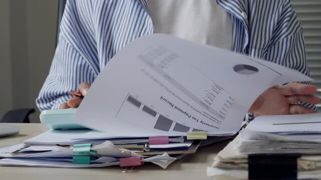 Female business assistant reviewing contract papers and office files, representing administrative support, approval process, corporate documentation, client service, and organized workflow.