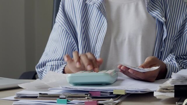 Administrative assistant checking receipts with calculator and document stacks, showing bookkeeping, budget control, invoice review, tax filing, financial planning, and busy office workflow.