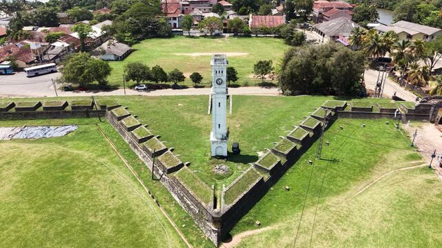 Aerial view of the historic Matara Clock Tower standing within the star-shaped fort walls surrounded by green lawns and urban buildings in Matara, Southern Province, Sri Lanka.