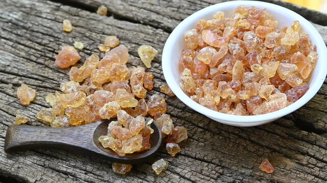 Raw tree gum resin, Organic tree Gum resin chunks in a white bowl and wooden spoon on wooden table background