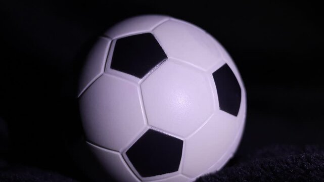 Una toma de cerca de una pelota o bal&oacute;n de f&uacute;tbol blanca con varias luces 