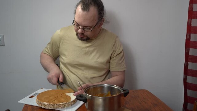 Man spread wafer cakes with condensed milk. Simple cake. Sweet food at home. Hands spreadind cream with knife.