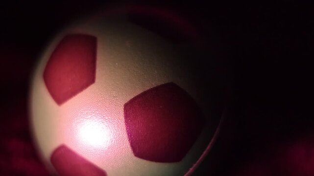  Una toma de cerca de una pelota o bal&oacute;n de f&uacute;tbol  con varias luces en un fondo negro 