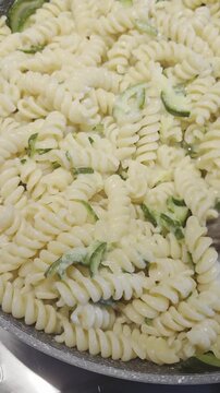 preparazopme di una ricetta con pasta fusilli in una padella sul fuoco