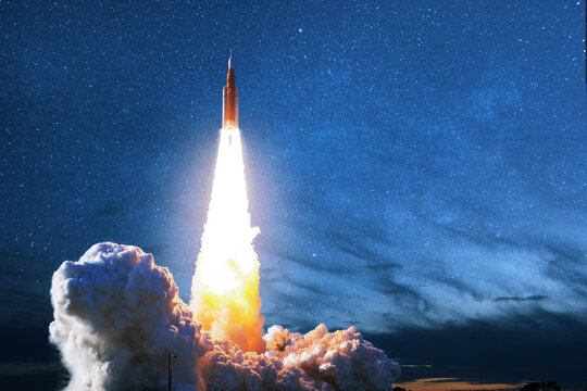 powerful space rocket launches into the starry night sky, leaving a spectacular trail of fire and thick smoke clouds. Rocket lift off. Elements of this image furnished by NASA
