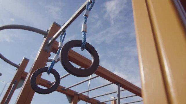 Street workout equipment stands ready for intense strength training session. Crisp natural daylight highlights modern details of park