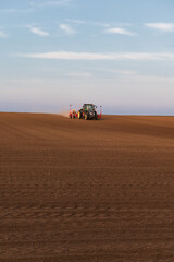 Fototapeta premium Tractor working on agricultural field in spring