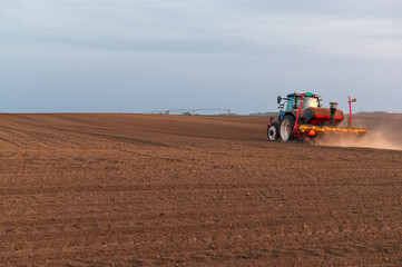 Fototapeta premium Tractor working on agricultural field in spring